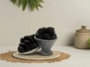 Premium Ajwa dates presented in a grey fluted pedestal bowl and side platter, highlighting the deep dark color and fine wrinkled texture of authentic Madinah dates.