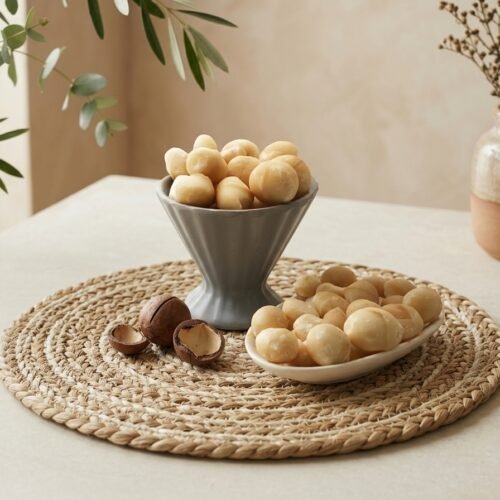 Oasis Dry Fruits Macadamia Kernels presented in a grey fluted bowl and side platter, featuring both whole kernels and natural shells for a luxury aesthetic.
