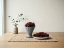 Premium dried cranberries by Oasis Dry Fruits in a grey pedestal cup and side plate, highlighting their vibrant ruby red color.