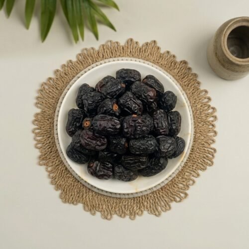 Close-up top-down shot of fresh Ajwa dates, showcasing the premium small-to-medium size and rich mineral content.