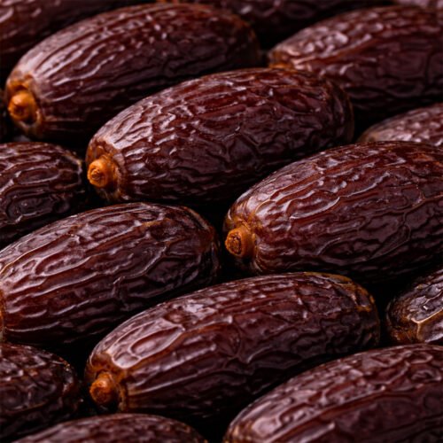Close-up of Oasis Medjool Super Jumbo dates showing their signature deep brown, wrinkled skin and large, plump size.