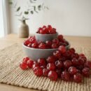 Premium dried cherries by Oasis Dry Fruits in a white bowl, showcasing their vibrant deep red color and plump, moist texture.