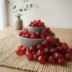 Premium dried cherries by Oasis Dry Fruits in a white bowl, showcasing their vibrant deep red color and plump, moist texture.