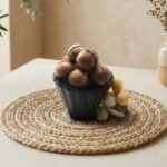 Premium macadamia nuts with shell by Oasis Dry Fruits, featuring a smooth, round dark brown shell protecting the creamy kernel.