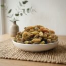 Sun-dried Afghan raisins premium served in a ceramic bowl by Oasis Dry Fruits.