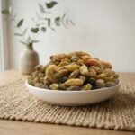 Sun-dried Afghan raisins premium served in a ceramic bowl by Oasis Dry Fruits.