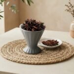 Natural whole Badiyan star anise pods served in a grey pedestal cup by Oasis Dry Fruits.