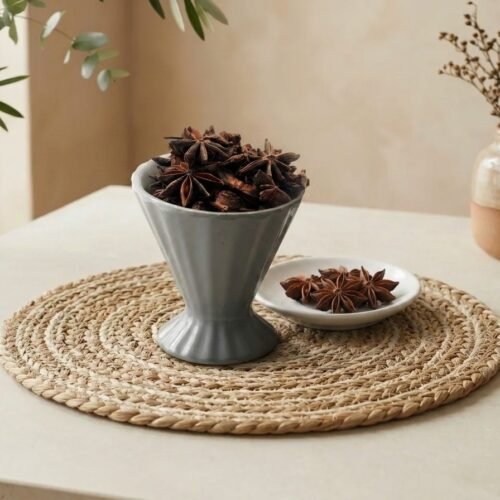 Natural whole Badiyan star anise pods served in a grey pedestal cup by Oasis Dry Fruits.