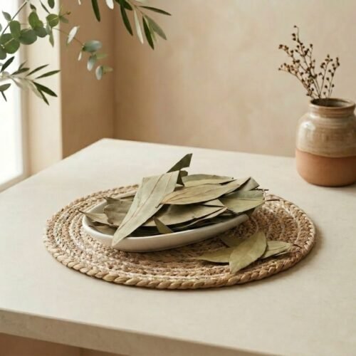 Side angle lifestyle shot of aromatic Bay Leaves in a ceramic dish by Oasis Dry Fruits.