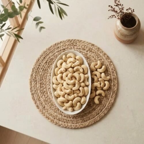 Top view flat lay of raw cashews premium large in an oval dish by Oasis Dry Fruits.