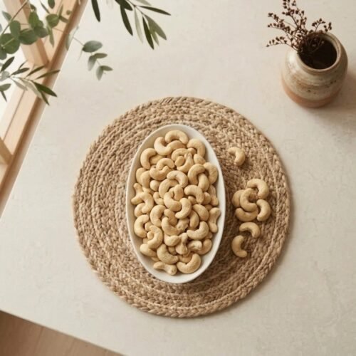 Top view flat lay of raw cashews standards in an oval white dish by Oasis Dry Fruits.