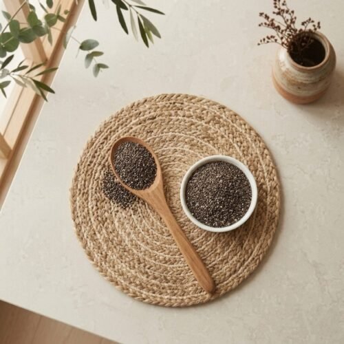 Top view flat lay of raw chia seeds in a white bowl with wooden spoon by Oasis Dry Fruits.