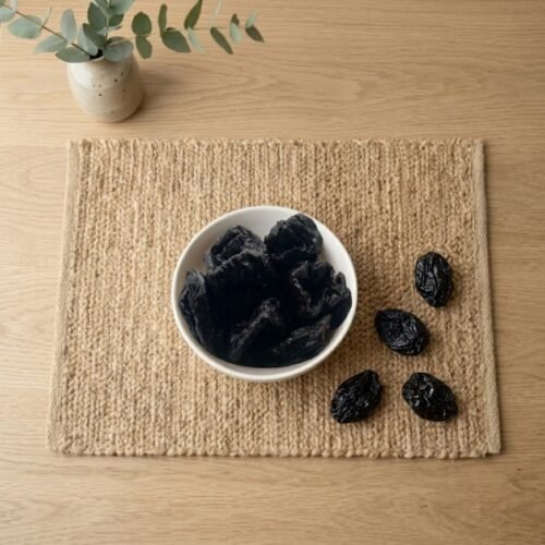 Top view flat lay of fresh dried prunes in a bowl by Oasis Dry Fruits.