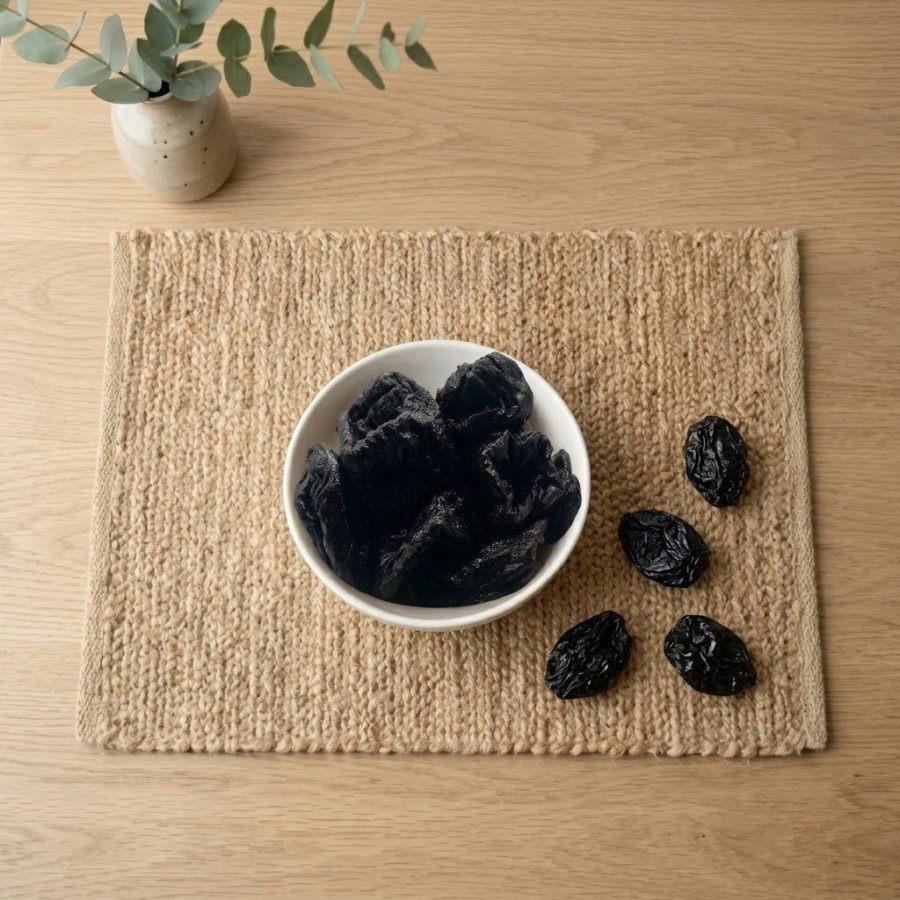 Top view flat lay of fresh dried prunes in a bowl by Oasis Dry Fruits.
