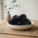 Premium organic dried prunes served in a white ceramic bowl by Oasis Dry Fruits.