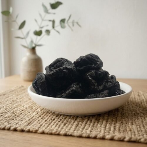 Premium organic dried prunes served in a white ceramic bowl by Oasis Dry Fruits.