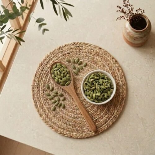 Top view flat lay of premium Green Cardamom 8mm pods with spoon by Oasis Dry Fruits.