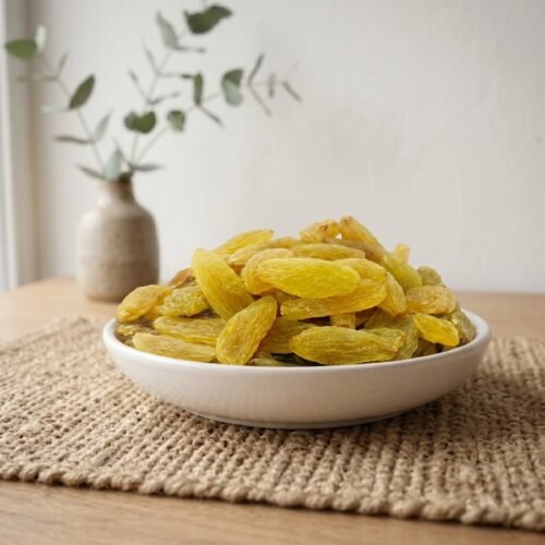 Indian Premium Golden Raisins served in a white ceramic bowl by Oasis Dry Fruits.