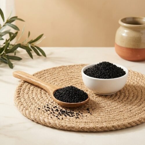Side angle lifestyle view of black kalonji seeds in bowl and spoon by Oasis Dry Fruits.