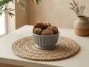 Raw kashmiri walnut with shell filled in a grey ceramic bowl by Oasis Dry Fruits.