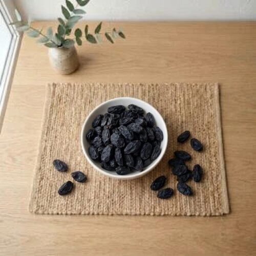 Top view flat lay of Large Black Raisins Without Seeds in a bowl by Oasis Dry Fruits.