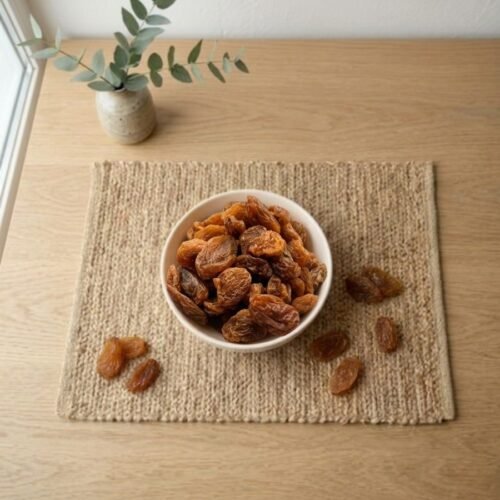Top view flat lay of sweet Munakka raisins in a bowl by Oasis Dry Fruits.