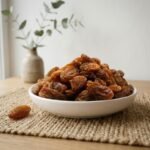 Premium organic Munakka served in a white ceramic bowl by Oasis Dry Fruits.