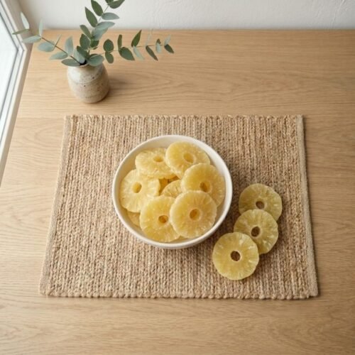 Top view flat lay of premium Pineapple (Dried) rings in a white dish by Oasis Dry Fruits.