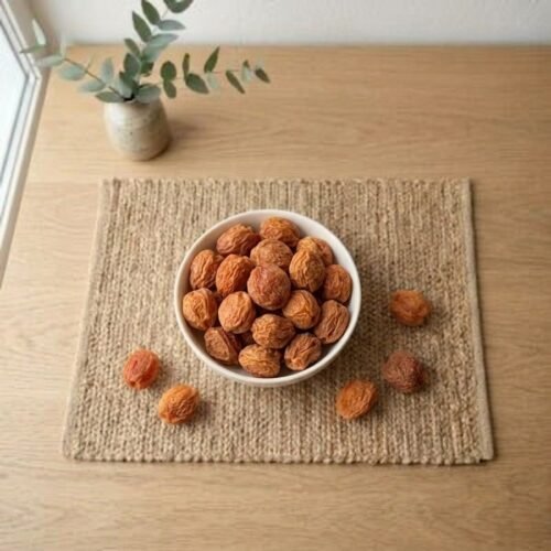 Top view flat lay of sun-dried Red Apricot (Ladakh) in a bowl by Oasis Dry Fruits.