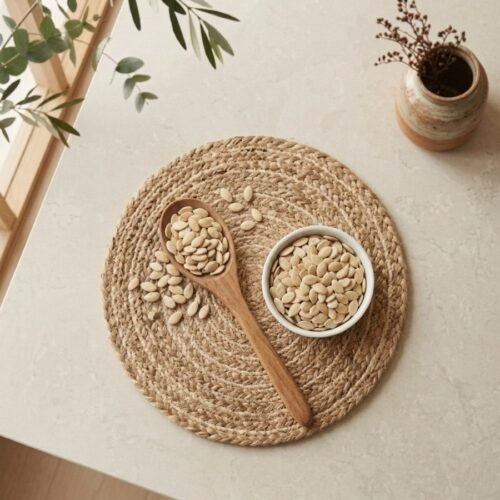 Top view flat lay of raw watermelon seeds in a white bowl with wooden spoon by Oasis Dry Fruits.