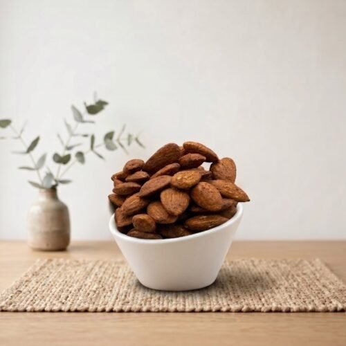 Side angle lifestyle shot of spicy Almonds Flavored (Mexican Chilli) in a white bowl by Oasis Dry Fruits.