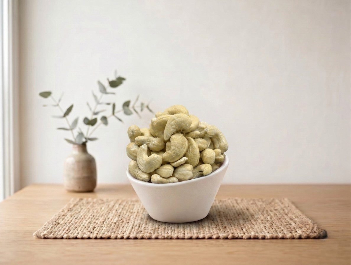 Side angle lifestyle shot of crunchy Cashew Flavored (Salted) in a white bowl by Oasis Dry Fruits.