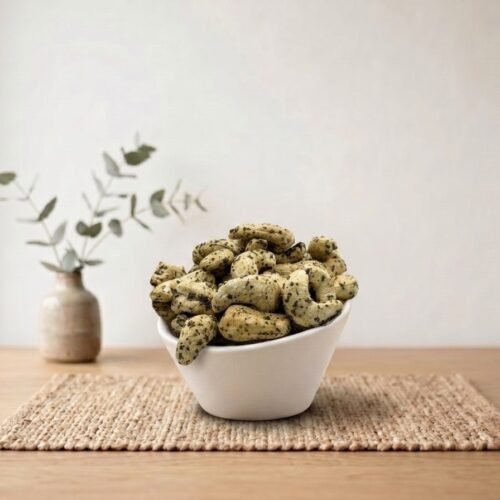 Side angle lifestyle shot of zesty Cashews Flavored (Black Pepper) in a white bowl by Oasis Dry Fruits.