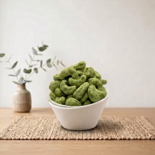Side angle lifestyle shot of spicy Cashews Flavored (Green Chilli) in a white bowl by Oasis Dry Fruits.