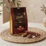 Cocoa Melts Hazelnut 100g pouch with milk chocolate wafer rolls and hazelnuts