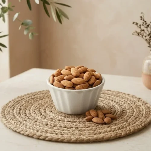 Side angle lifestyle shot of premium Kashmiri Almonds in a bowl by Oasis Dry Fruits.