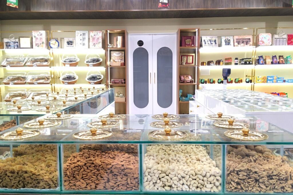 Inside the Oasis Dry Fruits store in Bangalore: glass dry fruit counter with almonds and cashews